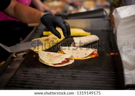 Male street vendor hands show fresh roasted meat and vegetables taco outdoors. Fresh tacos. Chef cooking mexican burito. Cook preparing delicious mexican burito at kitchen. Tasty mexican cuisine.