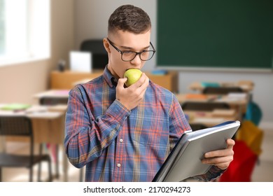 Male Student Eating Apple In Classroom