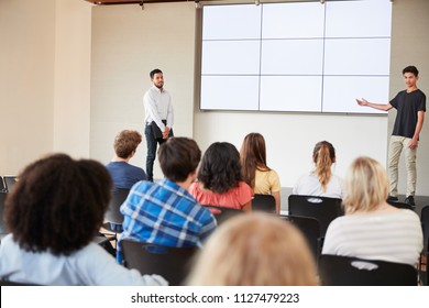 Male Student Giving Presentation To High School Class In Front Of Screen