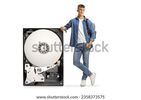 Male student leaning on a hard disk and looking at camera isolated on white background