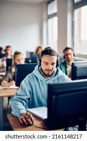 Male student learning on desktop PC during computer class at college classroom. - Shutterstock ID 2161148217