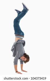 Male student posing handstands against white background
