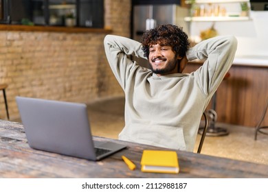 Male Student Resting With Hands Behind His Head And Looking At The Laptop Screen While Watching Lecture At Home. He Studying Remotely