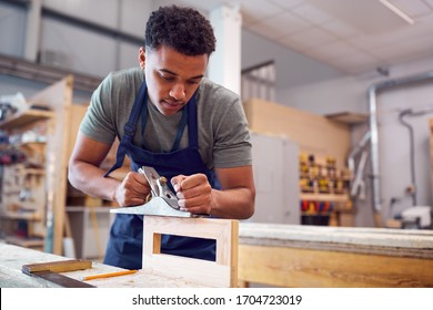 Male Student Studying For Carpentry Apprenticeship At College Using Wood Plane - Shutterstock ID 1704723019