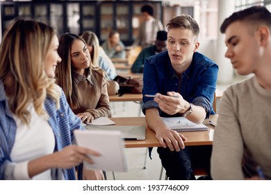 Male student talking to his friends during lecture in the classroom. 