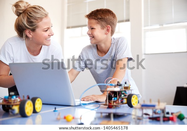 Male Student With Teacher Building\
Robot Vehicle In After School Computer Coding\
Class