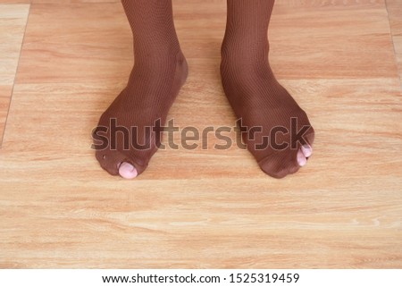 Male student in Thailand worn out socks with a hole or torn and toes sticking out of them.