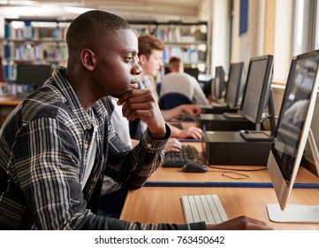 Male Student Working On Computer In College Library