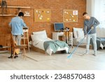 Male students cleaning in dorm room