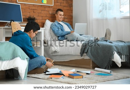 Male students doing homework in dorm room