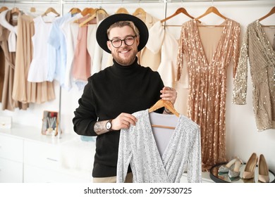 Male stylist with clothes in studio