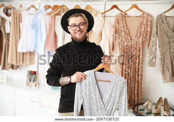 Male stylist with clothes\
in studio