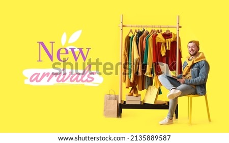 Male stylist near rack with modern clothes and text NEW ARRIVALS on yellow background