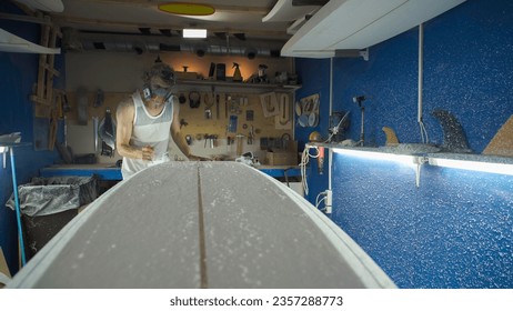 Male surfboard shaper making surfboard in his workshop. Hand shaping from blank. - Powered by Shutterstock