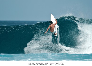 A male surfer executes a radical move on a beautiful ocean wave.