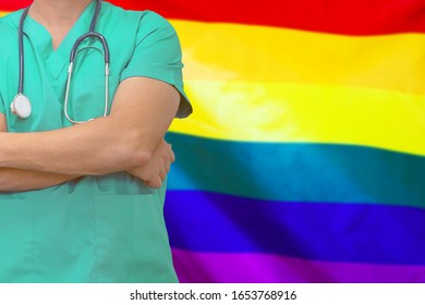 Male Surgeon Or Doctor With Stethoscope On The Background Of The LGBT Gay Flag. Health Care And Medical Concept. Surgery Concept In LGBT Gay .