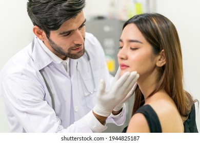 Male Surgeon Examining Young Asian Female's Face In Modern Clinic ,concept For Beauty Clinic Business