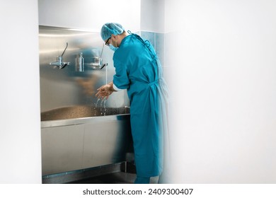 Male surgeon wearing operating gown washing hands before surgery. - Powered by Shutterstock