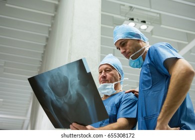 Male surgeons examining x-ray in hospital. Healthcare workers in the Coronavirus Covid19 pandemic
