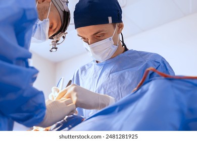 male surgeons perform surgery in operating room, plastic surgeon in operating room, A surgical team is carrying out an operation - Powered by Shutterstock