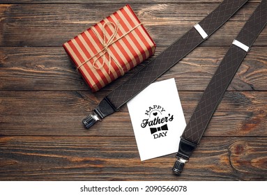 Male Suspenders With Greeting Card And Gift For Father's Day On Wooden Background