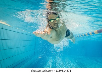 Male swimmer in the swimming pool.Underwater photo with copy space. - Powered by Shutterstock