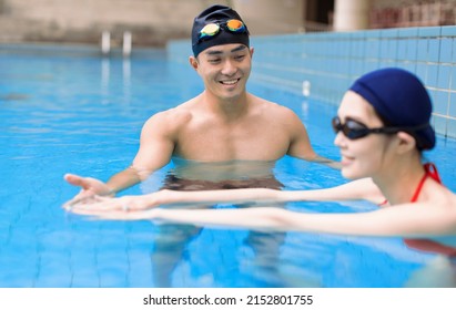 Male Swimming Teacher Giving woman One To One Lesson In Pool - Powered by Shutterstock