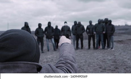 Male is talking to gang. Footage. Man gives speech to entire gang of gangsters in black jackets and masks. Criminal grouping with its own rules - Shutterstock ID 1609490569