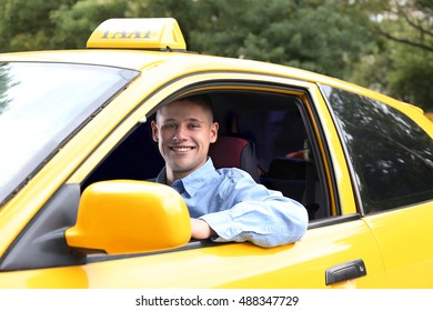 Male taxi driver in car