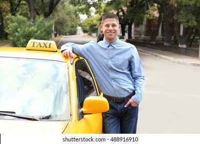 Male taxi driver near car