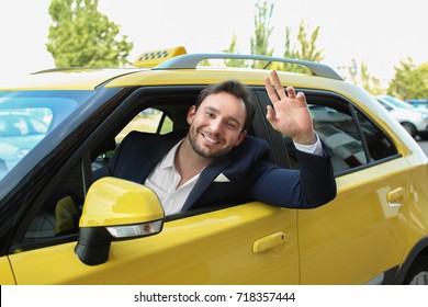 Male taxi driver sitting in yellow car
