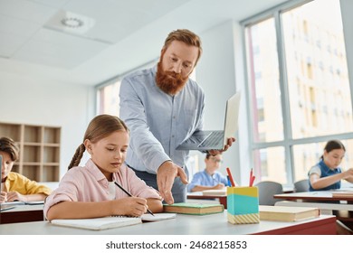 A male teacher assists a young girl with her homework in a vibrant classroom setting, surrounded by a diverse group of engaged students. - Powered by Shutterstock