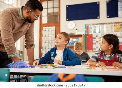 Male teacher in classroom helping multiethnic kids for studying at desk. Little schoolgirls in classroom asking for help with homework. Confident teacher helping elementary students during lesson. - Powered by Shutterstock