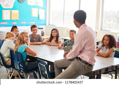 Male Teacher With Elementary School Kids In Class Discussion