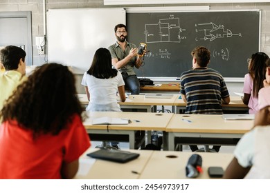 Male teacher giving technology presentation at high school students - Powered by Shutterstock