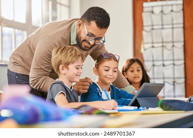 Male teacher helping schoolchildren in a research work using digital tablet in classroom. Three elementary school pupils working on digital tablet at desk while talking to teacher.  - Powered by Shutterstock