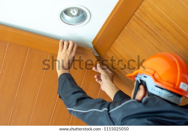 Male Technician Checking Ceiling Cornice Installation Stock