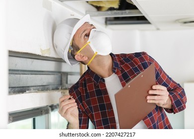 Male Technician Cleaning Industrial Air Conditioner Indoors