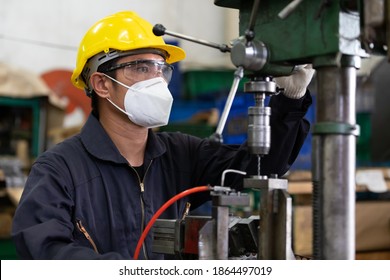 Male Technician Or Factory Worker Wearing Face Mask For Protect Virus, Using The Machine In Factory