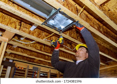 Male Technician Mounted Air Heating And Cooling System On Ceiling Steel Roof Structure Ventilation System