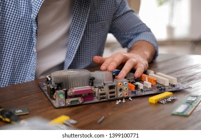 Male technician repairing motherboard at table, closeup - Shutterstock ID 1399100771