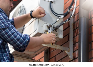 Male Technician Repairing Outdoor Air Conditioner Unit