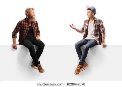 Male Teen Student Sitting On A Blank Panel And Talking To A Bearded Guy Isolated On White Background