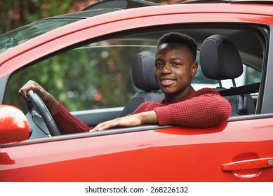 Male Teenage Driver Looking Out Of Car Window