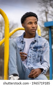 Male teenager sitting on playground equipment
