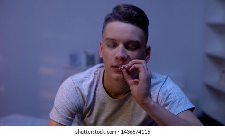 Male Teenager Smoking Weed Joint, Evening At Home, Awkward Age Experiment