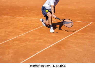 Male Tennis Player In Action On The Clay Court On A Sunny Day