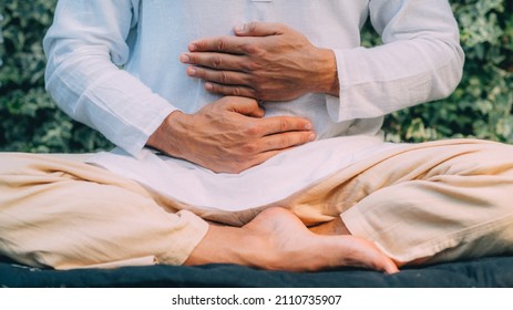 Male Therapist Performing Reiki Therapy Self-treatment Holding Hands Over His Stomach. Alternative Therapy Concept. 