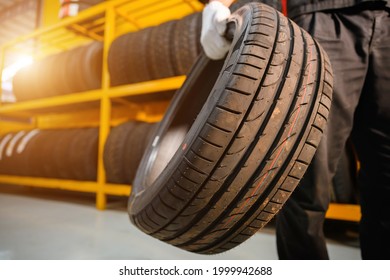 male tire changer In the process of checking the condition of new tires that are in stock to be replaced at a service center or auto repair shop Tire depot for the automobile industry - Shutterstock ID 1999942688