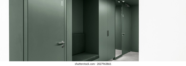 Male Toilet Sign On A Modern Green Restroom Door With Comfortable Lounge Area Next To The Door.  Sexual Gender Social And Cultural Issues Concept Background. No People. Copy Space